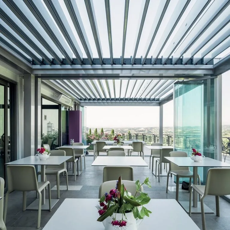 Terrasse de café sous pergola bioclimatique